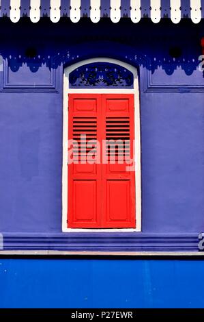 Vorderansicht des bunten Erbe Singapur shop Haus mit blauen Fassade, antiken rot Lamellenfensterläden und gewölbten Fenster in historischen Little India Stockfoto