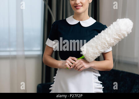 7/8 Schuß von glücklichen Mädchen in Uniform mit Duster Stockfoto