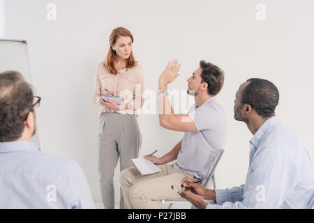 7/8 Schuß des mittleren Alters multiethnischen Menschen zusammen sprechen während der anonymen Gruppe Therapie Stockfoto