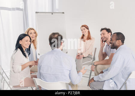 Multiethnischen im mittleren Alter Menschen reden und lächeln während der Gruppe Therapie Stockfoto