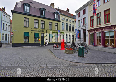 Ein Platz im Zentrum von Brügge mit einem hellen roten Briefkasten und die berühmte Diamant (Diamant) Museum hinter und Tanuki japanisches Restaurant. Stockfoto