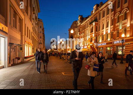Moskau, Russland - 21. September 2017: Volk und historischen Gebäude, das von warmen Licht Arbat dekoriert Straße zu Fuß in der Dämmerung mit blauem Himmel. Stockfoto