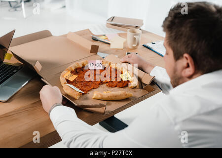 Übergewicht Geschäftsmann essen Pizza am Arbeitsplatz im Büro Stockfoto
