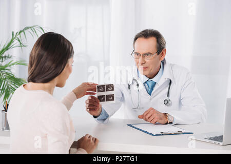 Männlicher Arzt zeigen schwangere Frau Foto der Ultraschalldiagnostik Stockfoto