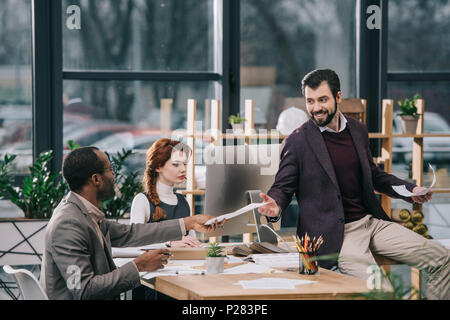 Multiethnischen Architekten diskutieren, Pläne im modernen Büro Stockfoto