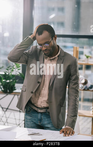 Nachdenklich, african american Architect bei Baupläne suchen Stockfoto