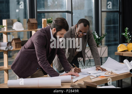 Junge Architekten zeichnen Baupläne zusammen ausgerichtet Stockfoto