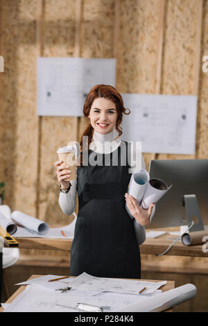 Überforderten jungen architekten schlafen auf Baupläne am Arbeitsplatz Stockfoto