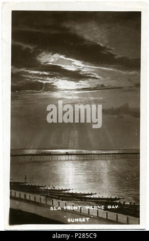 . Postkarte Foto vom Sonnenuntergang über Herne Bay Pier, Postmarked 1913. Der Wagen kann zwischen zwei Unterstände am 3 pier Herne Bay gesehen werden, und drei Segelboote sind hinter dem Pier. Der Fotograf war Fred C. Palmer von Tower Studio, Herne Bay, Kent, der geglaubt wird, gestorben 1936-1939 haben. Grenze der verbleibende Rand dieses Bildes ist wichtig für die Forscher von dieser Fotograf. Einige Fotografen schmückten ihre Bilder mehr als andere, und Palmer hat einen guten Ruf für die Herstellung von kleineren Postkarten als andere frühe 20. Jahrhundert britischen Fotografen. Er nahm seine eigenen Fotos, In-house ont entwickelt Stockfoto