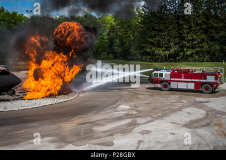 Flieger von der 179th Airlift Wing Feuerwehr, Mansfield, Ohio, Durchführung aircraft Crash Recovery Training, 4. Juni 2018, an der Alpena Combat Readiness Training Center, Alpena, Michigan statt. Flieger verwenden Löschfahrzeuge Kreis der simulierten Flugzeugabsturz Website und die Flammen durch eine kontrollierte Propan live Fire System erstellt, löschen. Das Training ist auf volle Spektrum Bereitschaft Vorbereiten der Tragfläche zu lokalen, staatlichen oder bundesstaatlichen Aktivierungen zu einem Momente bemerken zu reagieren. (U.S. Air National Guard Foto von Kapitän Paul Stennet/Freigegeben) Stockfoto