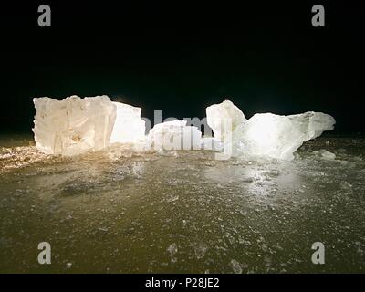 Blue ice cubes glänzen auf flachen Gletscher Oberfläche. Dank spot light/-gekrümmte Details im Inneren des Eis, gefroren Blasen und Kratzern. Stockfoto