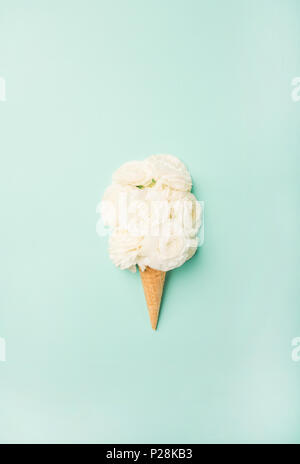 Waffel Kegel mit weißen Blüten auf blauem Hintergrund, Ansicht von oben Stockfoto