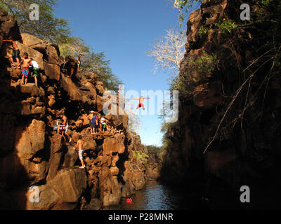 Ein Mann springt von einer Klippe in Las Grietas Kanal im Galapagos Archipel Stockfoto