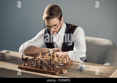 Konzentrierte junge Unternehmer in Brillen Schach spielen Stockfoto