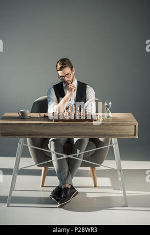 Nachdenkliche junge Unternehmer in Brillen Schach spielen Stockfoto