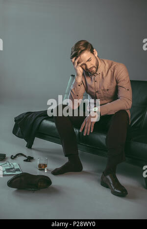 Junge Unternehmer leiden unter Kopfschmerzen beim Sitzen auf der Couch Stockfoto