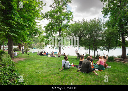 Madrid Retiro Park, Blick auf eine Gruppe von jungen Leuten, die ein Picknick in der Nähe des Sees im Parque del Retiro im Zentrum von Madrid, Spanien. Stockfoto