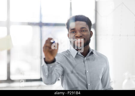 Geschäftsmann schreiben auf Glas Bord im Büro Stockfoto