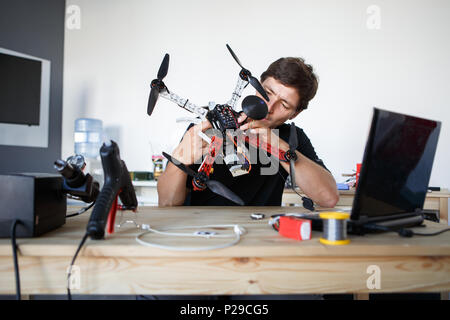Bild des Ingenieurs ausbessern square Cop am Tisch sitzen im Zimmer Stockfoto