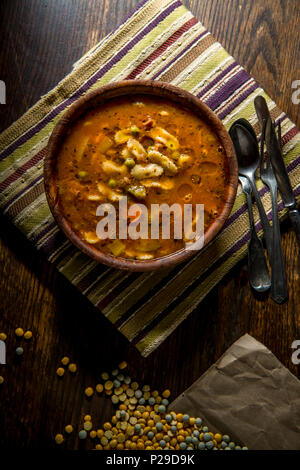 Rustikale hausgemachte herzhafter Tomaten Gemüse Suppe in eine hölzerne Schüssel Stockfoto