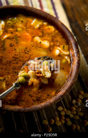Rustikale hausgemachte herzhafter Tomaten Gemüse Suppe in eine hölzerne Schüssel Stockfoto