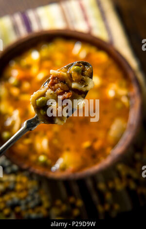Rustikale hausgemachte herzhafter Tomaten Gemüse Suppe in eine hölzerne Schüssel Stockfoto