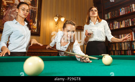 Junge Frauen spielen Billard im Büro nach der Arbeit. Stockfoto