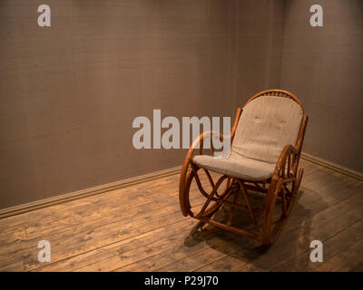 Rattan Schaukelstuhl in den leeren Raum mit Holzboden, Konzept indoor Zusammensetzung Stockfoto