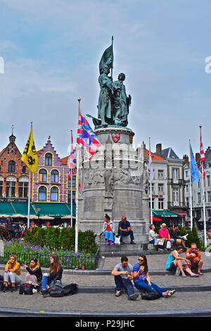 Gruppen von jungen Leuten/Studenten sitzen in Gruppen unter der Statue von Jan Breydel und Pieter deConinck Louis Delacenserie, in Brügge oder Brügge, Belgien Stockfoto