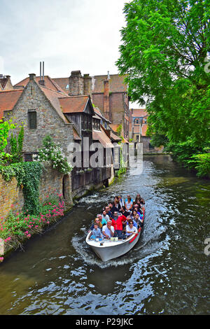 Eine beliebte Kanal tour Boot voller Touristen Ansätze die Bonifacius Brücke in ein hübsches und malerischen Teil der Groeninge, Brügge oder Brügge, Belgien Stockfoto