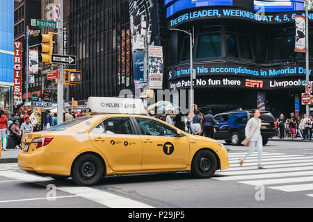 Gelbes Taxi wartet an der Ampel in New York, Fußgänger vor. Stockfoto