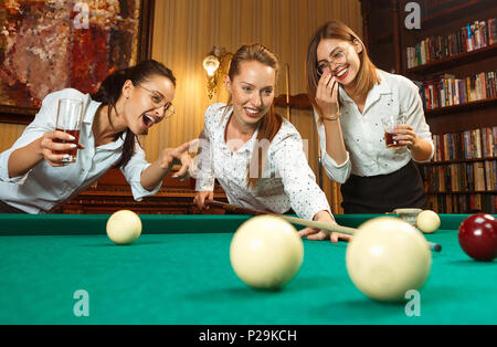 Junge Frauen spielen Billard im Büro nach der Arbeit. Stockfoto