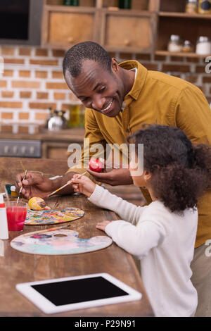 African American Vater und Tochter Malerei Ostereier Stockfoto