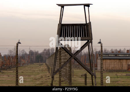 Wachturm sitzt entlang eines einmal elektrischen Zaun in Auschwitz-Birkenau auf Sonnenuntergang Stockfoto