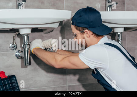Nahaufnahme der jungen professionellen Klempner zur Festsetzung Waschbecken im Badezimmer Stockfoto