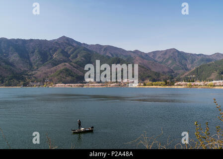 Lone Fischer auf einem Boot auf dem See Kawaguchi, Yamanashi Präfektur, Japan Stockfoto