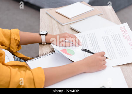 Schuß von Frau Schreibarbeit tun am Arbeitsplatz 7/8 Stockfoto