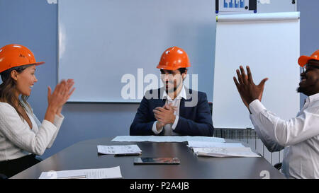 Erfolgreich im Geschäft gemischtrassiges Team von Ingenieuren Erfolge feiern die Hände schütteln und lächeln Stockfoto