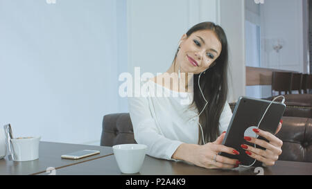 Hübsche junge Frau prüfen ihr Make-up mit Tablet und Vorbereitung auf die Videokonferenz Stockfoto
