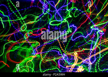 Die chaotischen verschwommene Linien der Farbe leuchtet auf dunklem Hintergrund. Bunte Lichter verschwommen durch Bewegung. Stockfoto