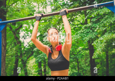 Fitness Frau Vorbereitung für das Tun pullups in der Natur. Gesunder Lebensstil Konzept. Stockfoto