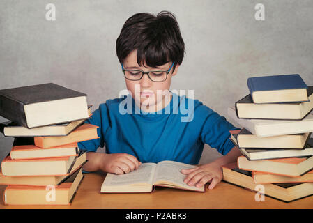 Junge lesen Bücher auf grauem Hintergrund Stockfoto