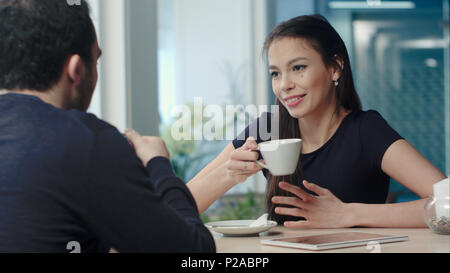 Mann und Frau im Gespräch in einem Café bei einer Tasse Kaffee in Stockfoto