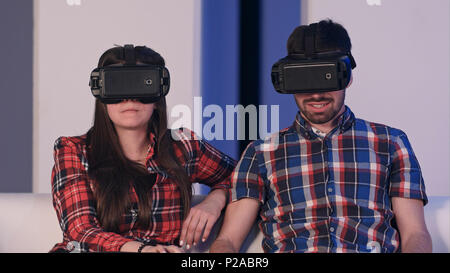 Junges Paar im VR-Headset ansehen Film sitzt auf einem Sofa Stockfoto