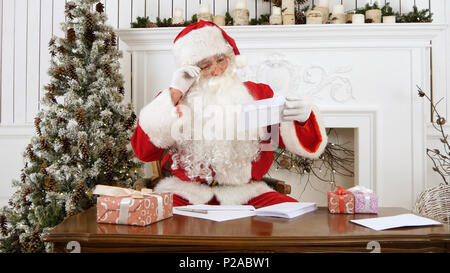 Santa Claus sortieren aus Papier Briefe von Kindern Stockfoto