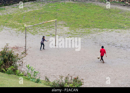 GHALEGAUN, Nepal - ca. Mai 2018: Kinder spielen Fußball. Das Ziel ist der Baum verzweigt. Stockfoto