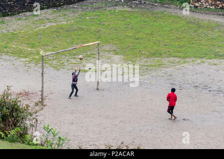 GHALEGAUN, Nepal - ca. Mai 2018: Kinder spielen Fußball. Das Ziel ist der Baum verzweigt. Stockfoto