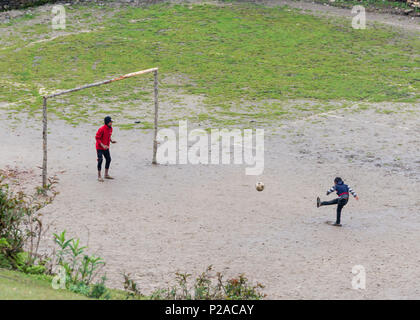 GHALEGAUN, Nepal - ca. Mai 2018: Kinder spielen Fußball. Das Ziel ist der Baum verzweigt. Stockfoto