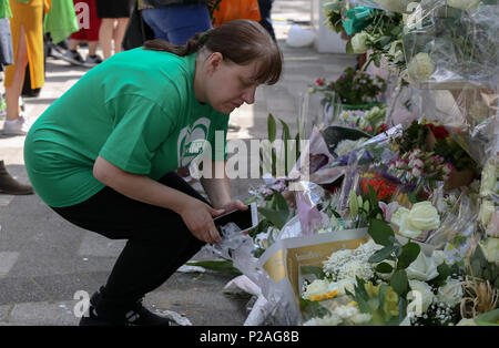 West London. London. UK vom 14. Juni 2018 - die Mitglieder der Familie legen Kränze, Blumen und Anzünden von Kerzen an der Basis von Grenfell Turm außerhalb Kensington Freizeitzentrum. Das Feuer brach am 14. Juni 2017, in dem 24-stöckigen Hochhaus Grenfell von Sozialwohnungen Wohnungen in Kensington, West London, bei denen 72 Menschen ihr Leben verloren. Credit: Dinendra Haria/Alamy leben Nachrichten Stockfoto