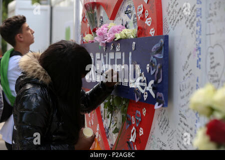 West London. London. UK vom 14. Juni 2018 - die Mitglieder der Familie legen Kränze, Blumen und Anzünden von Kerzen an der Basis von Grenfell Turm außerhalb Kensington Freizeitzentrum. Das Feuer brach am 14. Juni 2017, in dem 24-stöckigen Hochhaus Grenfell von Sozialwohnungen Wohnungen in Kensington, West London, bei denen 72 Menschen ihr Leben verloren. Credit: Dinendra Haria/Alamy leben Nachrichten Stockfoto